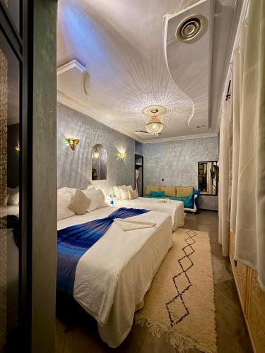 a hotel room with two beds and a couch at Riad Tama & SPA - Authentic Ourzazate Stay in Ouarzazate
