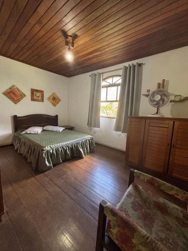a bedroom with a bed and a window with a fan at Cozy Farmhouse with Pool in Bom Jardim in Bom Jardim