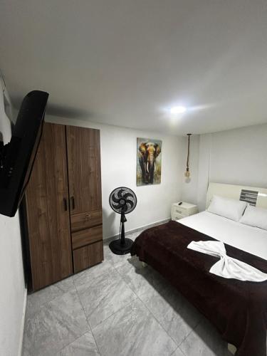 a bedroom with a bed and a television in it at Apartamento amoblado Chinchina in Chinchiná