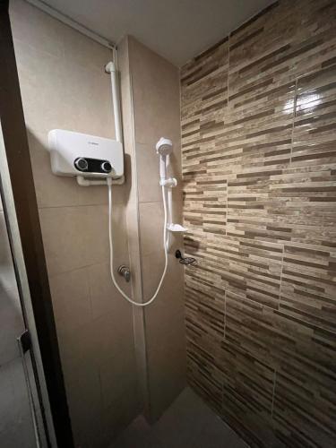 a shower in a bathroom with a stone wall at Apartamento amoblado Chinchina in Chinchiná