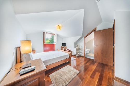 a bedroom with a bed and a desk with a lamp at Casa da Obrinha in Bouro
