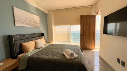 a bedroom with a bed with a view of the ocean at Grandeza by Palms Boca del Río in Boca del Río