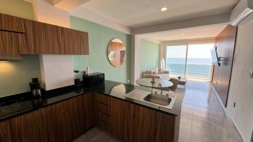 a kitchen with a sink and a view of the ocean at Grandeza by Palms Boca del Río in Boca del Río