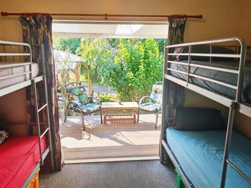 a room with two bunk beds and a patio at Eco Lodge Pakowhai in Hastings