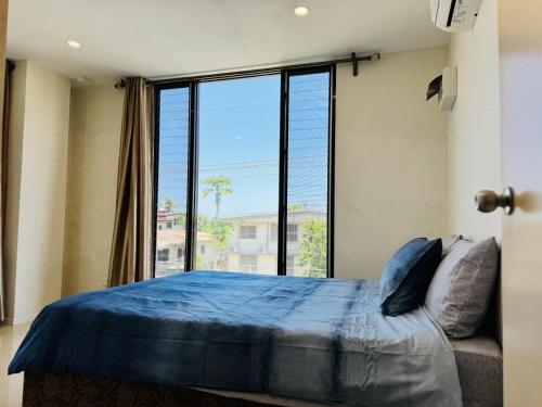 a bedroom with a bed and a large window at Trendy Edge Apartments in Nadi