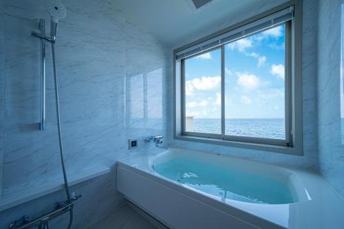 a bathroom with a bath tub and a window at THE ZK West Coast in Awaji