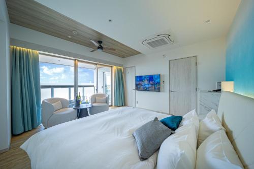 a bedroom with a large white bed with a table and chairs at THE ZK West Coast in Awaji