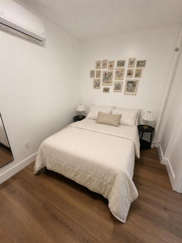a white bedroom with a bed and two lamps at The Revival Guest House near Times Square in New York