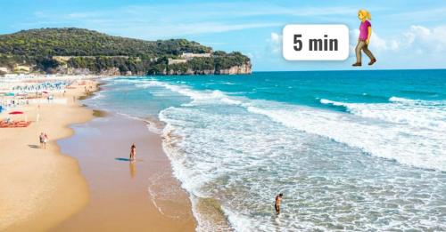 a picture of a beach with people playing in the water at Appartamento Deluxe Centrale, in Gaeta
