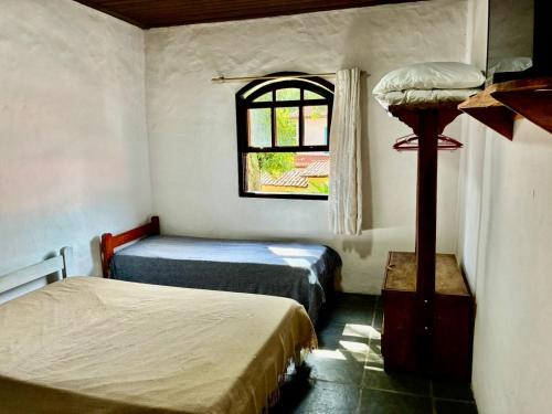 a room with two beds and a window at Chalés Bambá in Ilhabela