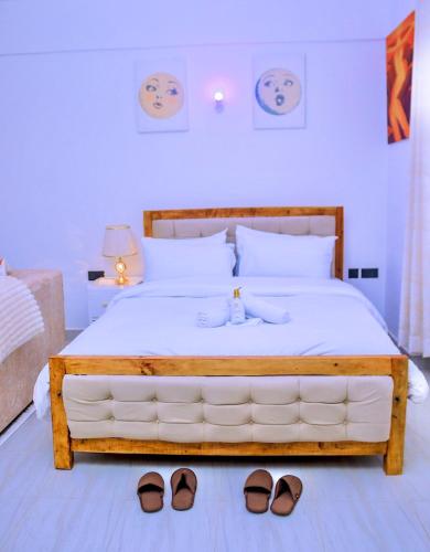 a bedroom with a bed with two pairs of shoes on it at Polea Hapa Ruaka in Nairobi
