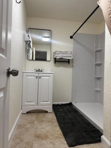 a bathroom with a sink and a shower with a mirror at Toiyabe Motel in Walker