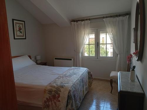a bedroom with a bed and a window at Apartamento manchego Macrina in Villarta de San Juan