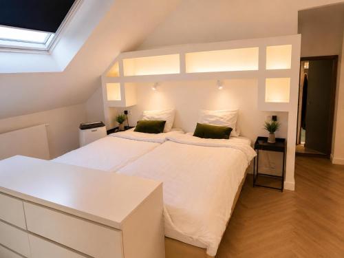 a bedroom with a large white bed with two pillows at Penthouse city & cathedral View for 4 in Antwerp