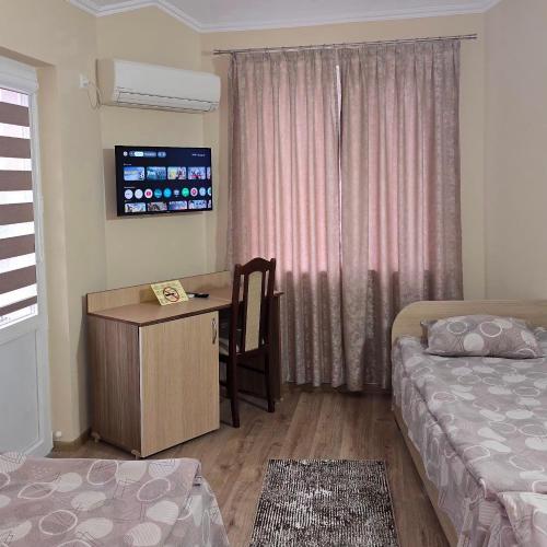 a bedroom with a desk and a bed and a table at Hotel Fantasy in Lyubimets