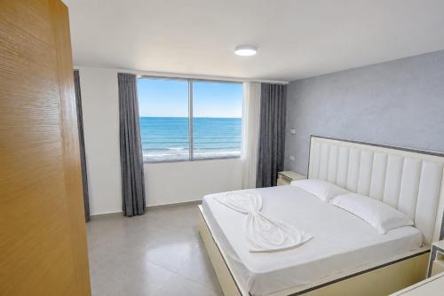 a bedroom with a bed with a view of the ocean at Luxury sea view duplex in Durrës