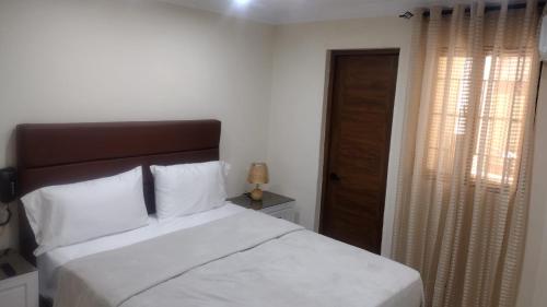 a bedroom with a large bed and a window at Johanna 1 in Los Tres Ojos de Agua