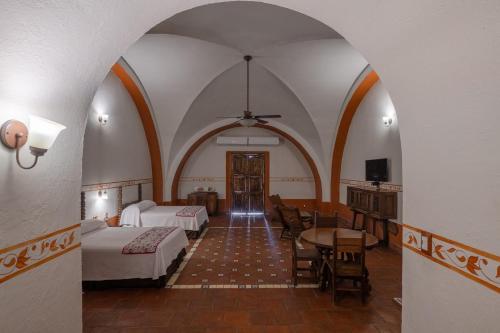 a hotel room with two beds and a table and chairs at Hotel Hacienda Vista Hermosa in Tequesquitengo
