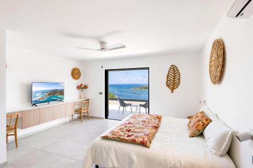a bedroom with a bed and a view of the ocean at Résidence AMARILLO Vue mer exceptionnelle face à Saint-Barthélémy in Cul de Sac