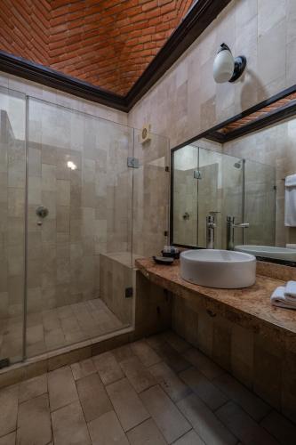 a bathroom with a sink and a shower at Hotel Hacienda Vista Hermosa in Tequesquitengo
