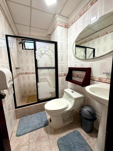a bathroom with a toilet and a sink at Hotel Nivel 5 in Macas