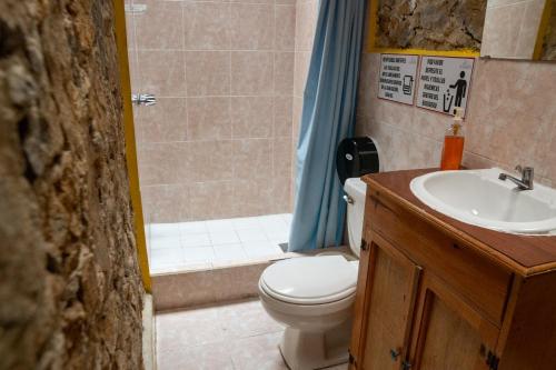 a bathroom with a toilet and a sink and a shower at Hotel Posada La Ermita Cobán in Cobán