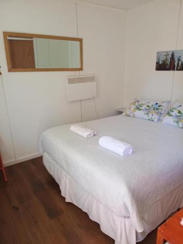 a bedroom with a bed with two towels on it at Borde Lago IV - V in Puerto Varas