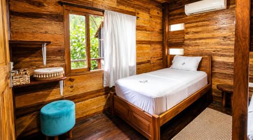 a bedroom with a bed in a log cabin at Luma by Zakua in Guachaca