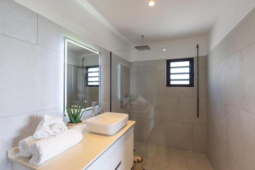 a white bathroom with a sink and a shower at Résidence AMARILLO Vue mer exceptionnelle face à Saint-Barthélémy in Cul de Sac