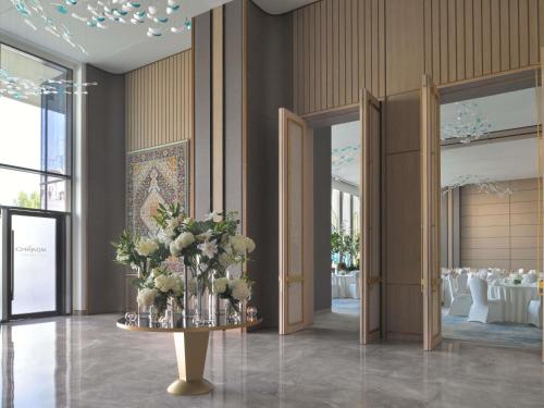 a banquet hall with a table with flowers on it at Mövenpick Hotel Tahlia Jeddah in Jeddah