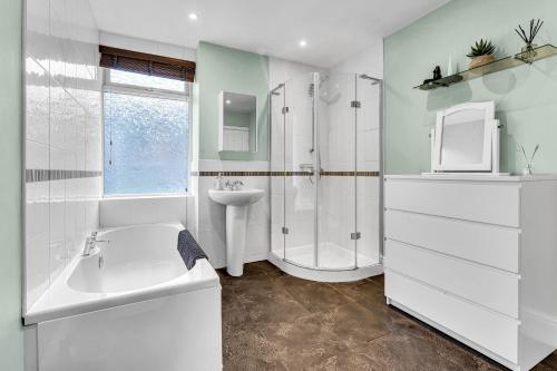 a white bathroom with a sink and a shower at Spacious Stoke Townhouse 3BR Near Hospital & M6 with Parking in Stoke on Trent