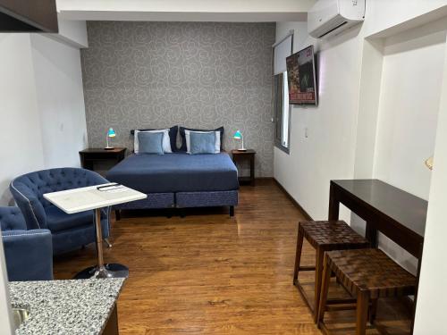 a hotel room with a bed and a chair at Departamento BLUE in San Juan