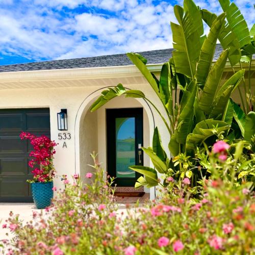 a house with a green door and some plants at Acqua Atelier by Vanderbilt Beach in Naples