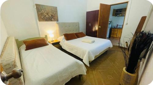 a hotel room with two beds and a kitchen at Apto en Minas con amplio fondo, aire acondicionado, ideal para descansar in Minas