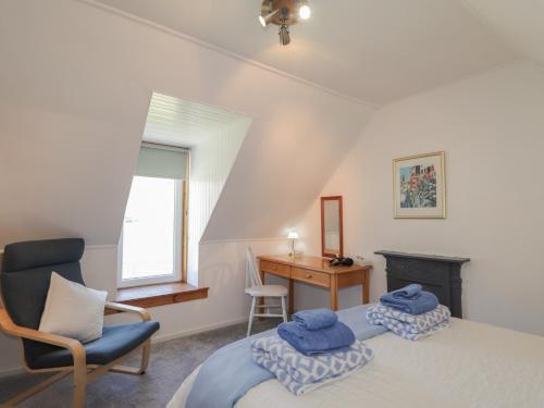 a bedroom with a bed and a chair and a desk at Tigh a Phailean in Letterfearn