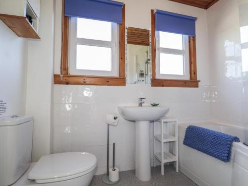 a white bathroom with a toilet and a sink at Tigh a Phailean in Letterfearn