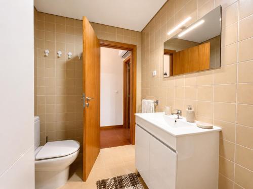 a bathroom with a toilet and a sink and a mirror at Gerês Trail House in Geres