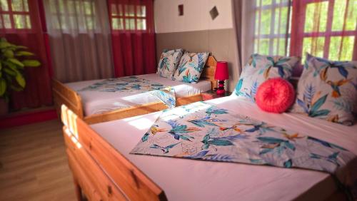 a room with three beds with pillows on them at Kay Lydie in Saint-Joseph