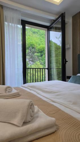 a bedroom with a bed and a large window at Kamel Rooms & Apartments in Bijelo Polje