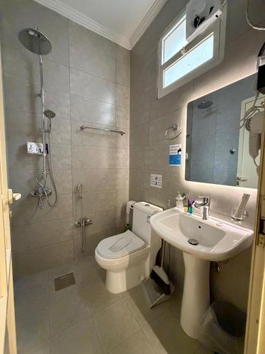 a bathroom with a toilet and a sink and a shower at شقة مروج هاوس دخول ذاتي in Hail