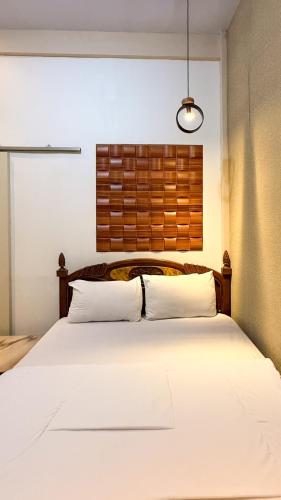 a bedroom with a large white bed with a window at Tafufu Villa Tumpak Sewu in Sumberbopong