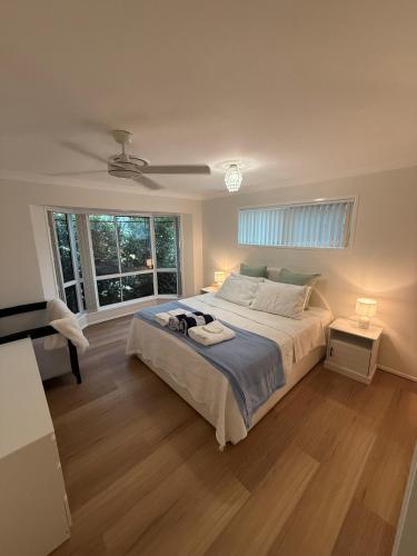 a bedroom with a large bed and a window at Pet Friendly - Plunge Pool Canal Sunset View - Private Jetty in Bongaree