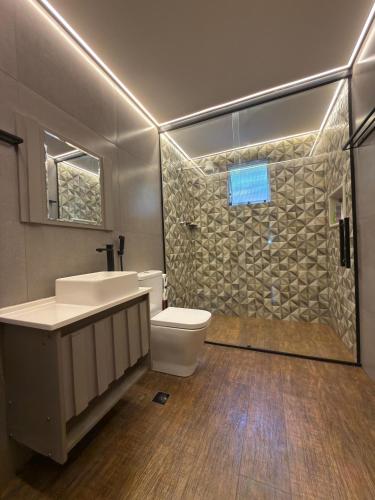 a bathroom with a toilet and a sink and a shower at Imperial Rodrigues Valley in Juquitiba