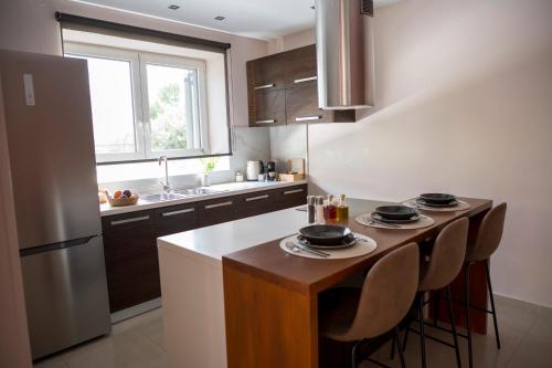 a kitchen with a table with chairs and a refrigerator at Jo's Apartment in Mytilene