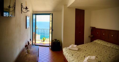 a bedroom with a bed and a view of the ocean at La Locandiera affittacamere in Scilla