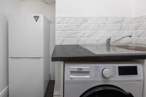 a kitchen with a sink and a washing machine at Cheshire Dimond one bedroom flat in Warrington in Warrington