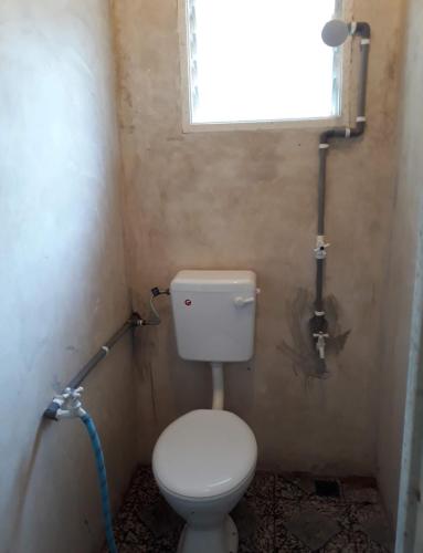 a small bathroom with a toilet and a window at Anjung Afilia 2 in Kuala Kangsar