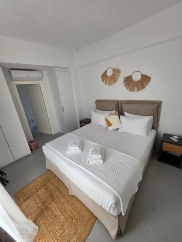a bedroom with a large white bed with two mirrors on the wall at Aura Sun Villa in Agios Romanos