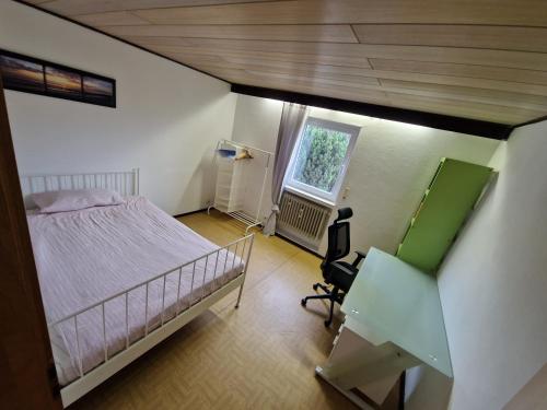 a bedroom with a bed and a desk and a window at Monteurenwohnung Chez Danou in Idar-Oberstein