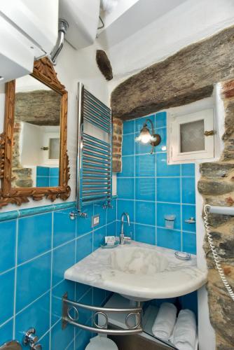 a blue bathroom with a sink and a mirror at The Vernazza Main Plaza - Rooms & Suites in Vernazza